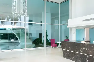 an office with glass walls and a pink chair at 1 Dormitorio con salida directa playa de Morros in Cartagena de Indias