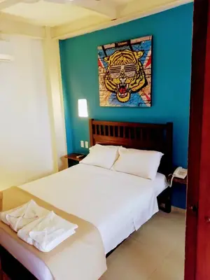 a bedroom with a bed with a tiger picture on the wall at Casa Ebano 967 in Cartagena de Indias