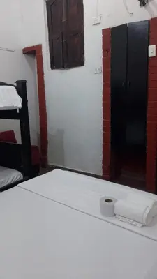 a room with a bed with a mirror and a closet at Hostal #10-33 in Cartagena de Indias