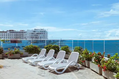 a row of white lounge chairs sitting on a roof at Luxury apartment, sector morros, vista y salida al mar edificio Sunshine in Cartagena de Indias