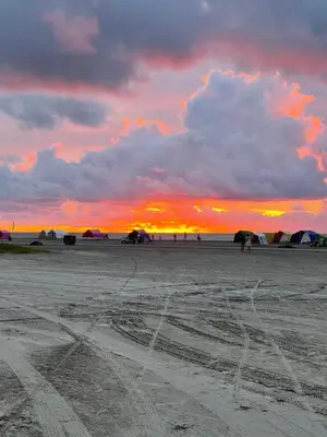 a sunset on a beach with tire tracks in the sand at Luxury apartment, sector morros, vista y salida al mar edificio Sunshine in Cartagena de Indias