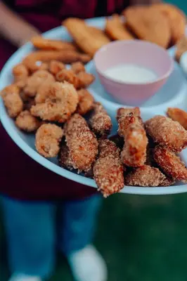a person holding a plate of onion rings and french fries at Casa Mambo Salinas in Santa Veronica