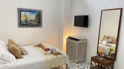 a bedroom with a white bed and a mirror at Casa Ego in Cartagena de Indias