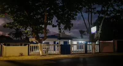 a fence in front of a house at night at Cabaña Perla Azul in Coveñas