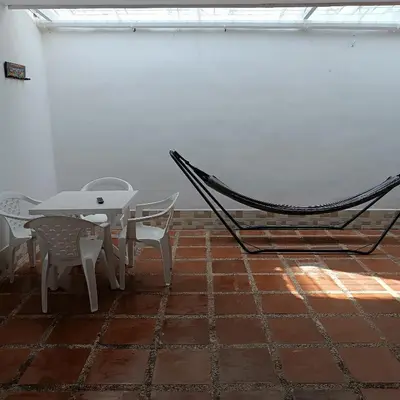 a hammock in a room with a table and chairs at Casa Para 3 a 12 personas in Cartagena de Indias