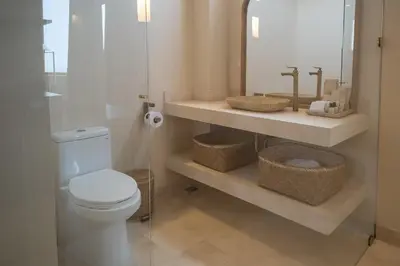 a bathroom with a toilet and a sink and a mirror at Hotel Aimarawa in Coveñas