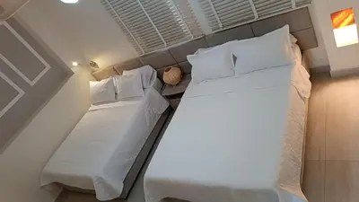 a bedroom with two beds with white sheets and pillows at Hermoso Apto en el corazón de la ciudad amurallada in Cartagena de Indias