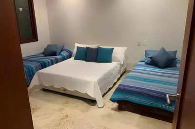 a bedroom with two beds with blue pillows at 212 Cartagena Walled City Magical Apt in Cartagena de Indias