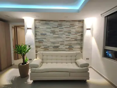 a living room with a white couch and a brick wall at APARTAMENTO MODERNO EL LAGUITO JUNTO AL MAR 705 in Cartagena de Indias