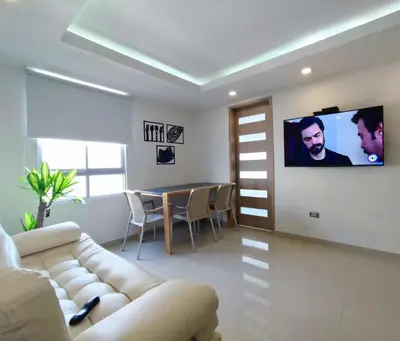 a living room with a couch and a tv on a wall at APARTAMENTO MODERNO EL LAGUITO JUNTO AL MAR 705 in Cartagena de Indias