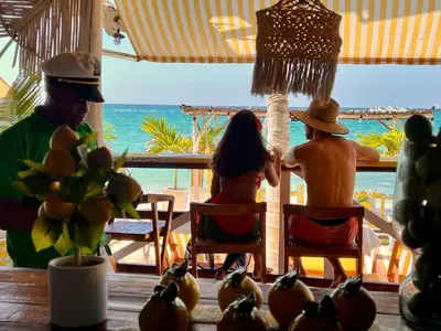 two people sitting at a table looking out at the ocean at Mio Mio Beach in Baru