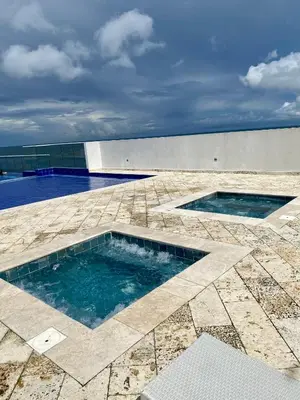 two swimming pools on a patio with a building at Ocean Drive Beach House - Cartagena in Cartagena de Indias