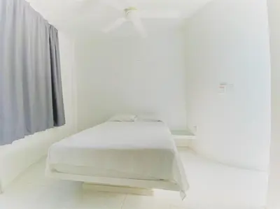a white bedroom with a white bed in a room at Casa Amarilla in Santa Veronica