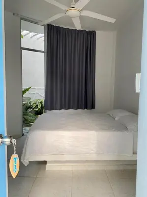 a bedroom with a white bed with a ceiling fan at Casa Amarilla in Santa Veronica