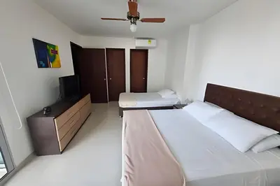 a small bedroom with a bed and a television at Apartamento 1 Dormitorio Morros. Vista Mar Piscina in Cartagena de Indias