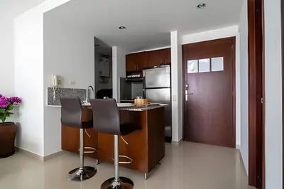 a kitchen with a counter and two bar stools at Apartamento 1 Dormitorio Morros. Vista Mar Piscina in Cartagena de Indias