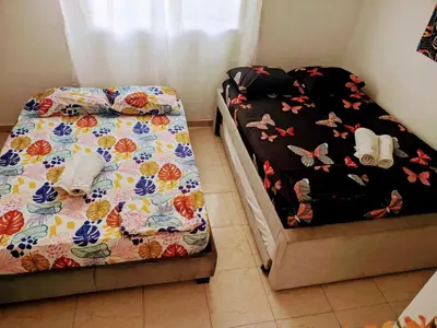 a bedroom with two beds and a bed with butterflies at Casa Pupo Hostal in Cartagena de Indias