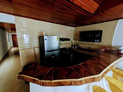 a kitchen with a black refrigerator in a room at Casa Pupo Hostal in Cartagena de Indias