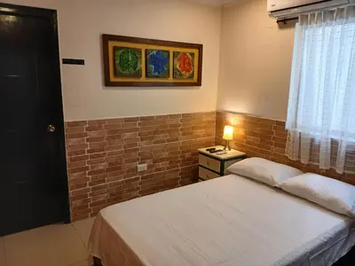 a bedroom with two beds and a brick wall at Apto amoblado barrio Los Alpes Cartagena in Cartagena de Indias