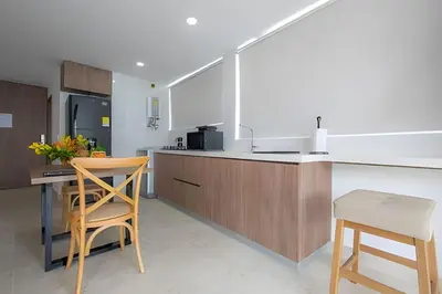 a kitchen with wooden cabinets and a counter top at Laurdhomes Laguito Loft Hot Ware 1Bath, lake view in Cartagena de Indias
