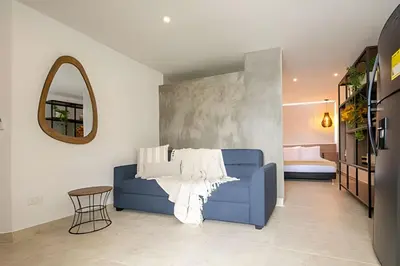 a blue couch in a living room with a mirror at Laurdhomes Laguito Loft , Hot Ware, 1Bath in Cartagena de Indias