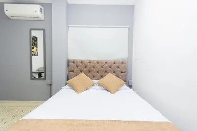 a bedroom with a white bed with two pillows at Hotel Med Suites 94 in Barranquilla