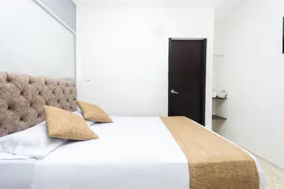a bedroom with a large bed with two pillows at Hotel Med Suites 94 in Barranquilla