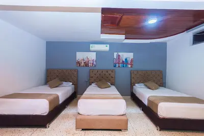 two beds in a room with blue walls at Hotel Med Suites 94 in Barranquilla