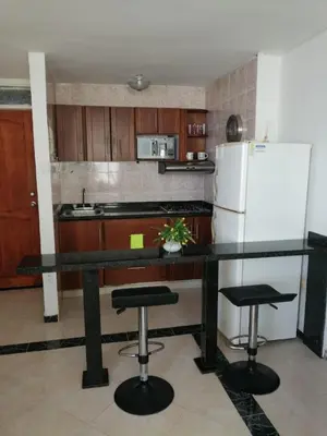 a kitchen with a black counter top and a refrigerator at Acogedor Apartamento Cartagena in Cartagena de Indias