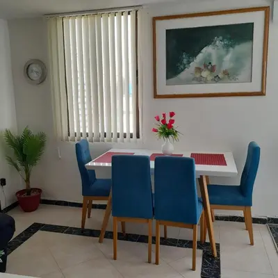 a dining room with a table and blue chairs at Acogedor Apartamento Cartagena in Cartagena de Indias