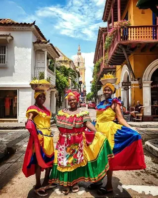 a group of three women in colorful dresses standing in a street at Cartagena ApartaSuite El Laguito in Cartagena de Indias