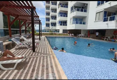 a group of people in a swimming pool at a hotel at Cartagena ApartaSuite El Laguito in Cartagena de Indias