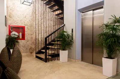 a lobby with a staircase and two potted plants at Sol de Alba Hotel Boutique in Cartagena de Indias