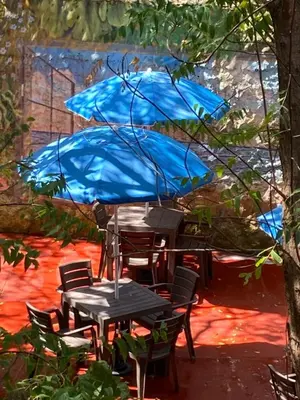 a table and chairs with a blue umbrella at Villa Margarita in Puerto Colombia