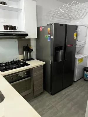a kitchen with a black refrigerator and a stove at Hermoso apartamento con vista al mar y salida directa a la playa in Cartagena de Indias