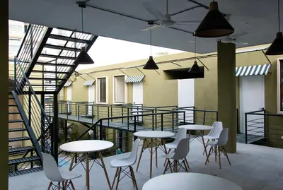 a group of tables and chairs on a balcony at OASIS TROPICAL HOTEL in Santa Marta