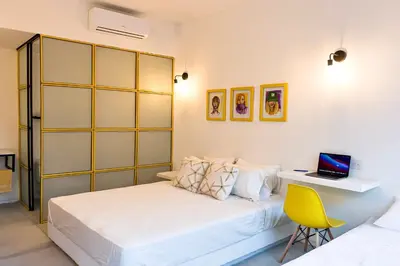 a bedroom with a bed and a desk with a laptop at OASIS TROPICAL HOTEL in Santa Marta