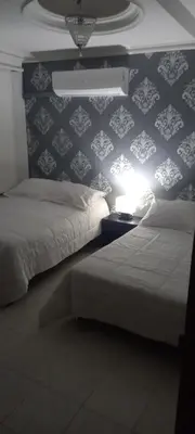 a bedroom with two beds and a blue wall at Cartagena Apartamento en Manga de 2 Habitaciones in Cartagena de Indias