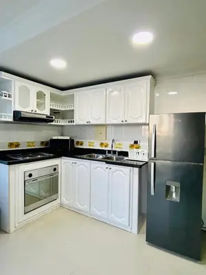 a kitchen with white cabinets and a stainless steel refrigerator at Apartamento in Cartagena de Indias