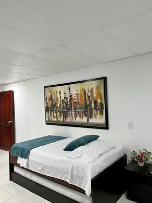 a bedroom with a bed with a painting on the wall at Apartaestudio in Cartagena de Indias