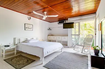 a bedroom with a white bed and a wooden ceiling at Casa Verde El Golf in Barranquilla