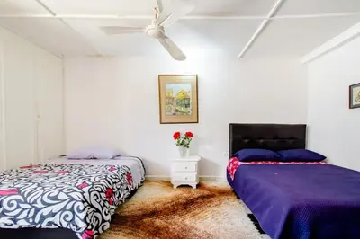 a bedroom with two beds and a ceiling fan at Casa Verde El Golf in Barranquilla