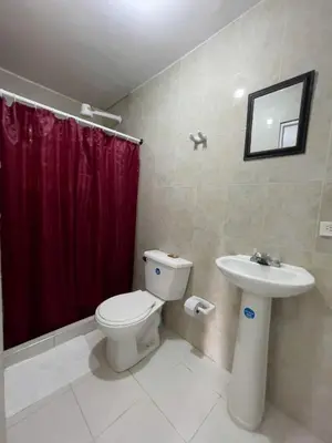 a bathroom with a toilet and a red shower curtain at 3CB-2 APARTAMENTO DE 3 ALCOBAS EN EL CENTRO HISTORICO CON AIRE ACONDICIONADO Y WIFI in Cartagena de Indias