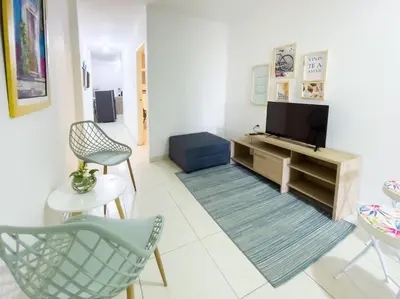 a living room with a tv and chairs at 2CB-3 APARTAMENTO DE 2 ALCOBAS EN EL CENTRO HISTORICO CON AIRE ACONDICIONADO Y WIFI in Cartagena de Indias