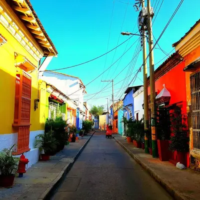 an empty street with colorful buildings on either side at 2CB-3 APARTAMENTO DE 2 ALCOBAS EN EL CENTRO HISTORICO CON AIRE ACONDICIONADO Y WIFI in Cartagena de Indias