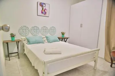 a bedroom with a large white bed with blue pillows at 2CB-4 APARTAMENTO DE 2 ALCOBAS EN EL CENTRO HISTORICO CON AIRE ACONDICIONADO Y WIFI in Cartagena de Indias