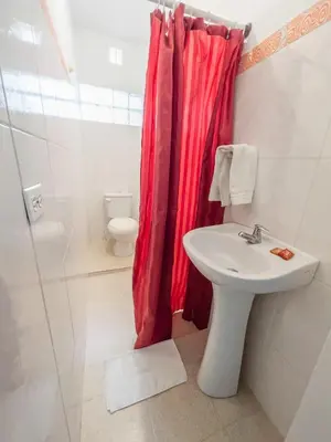 a bathroom with a sink and a red shower curtain at 2CB-4 APARTAMENTO DE 2 ALCOBAS EN EL CENTRO HISTORICO CON AIRE ACONDICIONADO Y WIFI in Cartagena de Indias