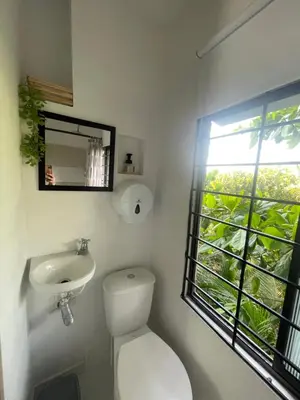 a bathroom with a toilet and a sink and a window at Casa Colors in Cartagena de Indias