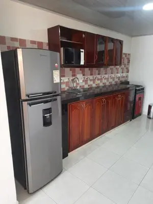a kitchen with a stainless steel refrigerator and wooden cabinets at VILLA MARIA in Turbaco