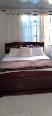 a large bed in a bedroom with a window at VILLA MARIA in Turbaco